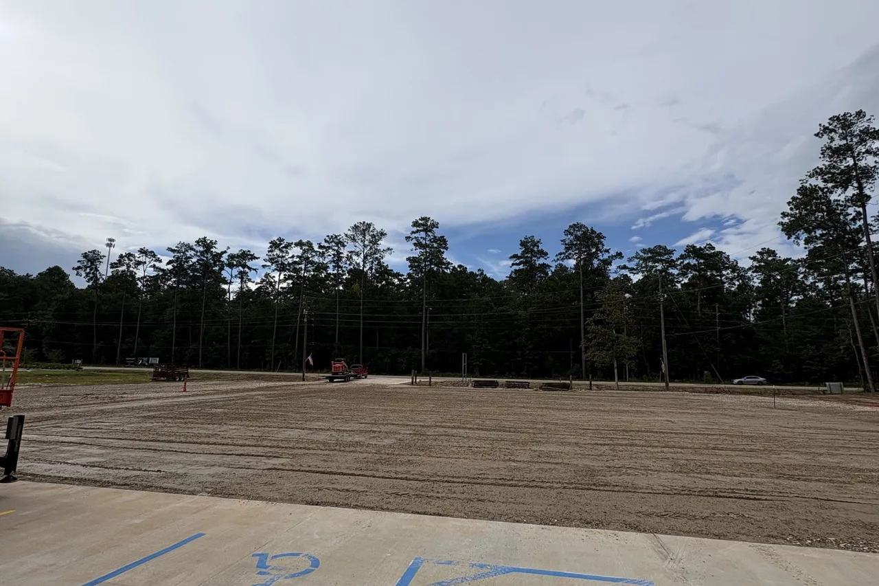 Compacted dirt building pad laid out inside a fenced backyard near Hammond, LA